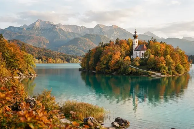 Ausflugsziele Kärnten: türkiser See mit Kirche auf einer Halbinsel im Herbst
