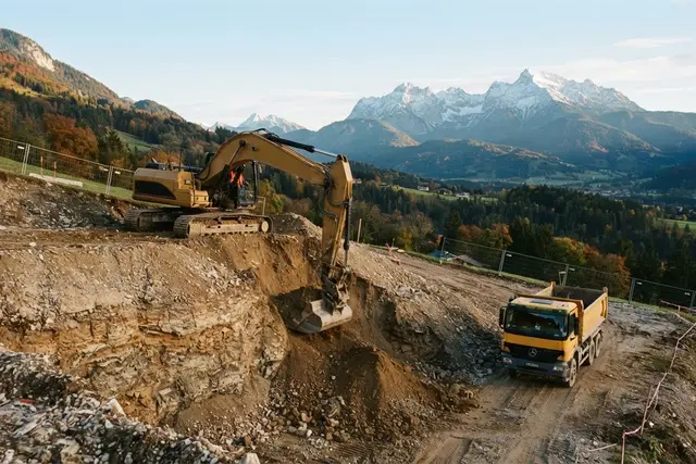 Aushub Baugrube: Bagger hebt Baugrube an einem Hang im Land Salzburg aus