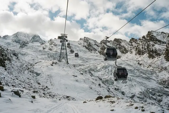 Gletscher-Skigebiete Österreich: Gondelbahn über einem verschneiten Gletscher im Oktober