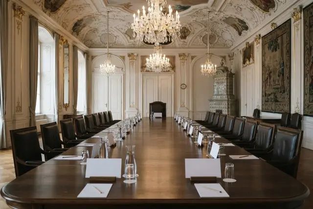 Leerer Regierungstisch in historischem Saal als Symbolbild zum Ministerrat