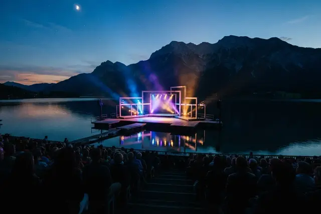 Musikfestivals Österreich: Freiluftbühne am See bei Abenddämmerung mit Publikum