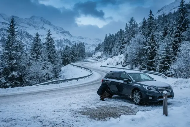 Schneekettenpflicht Österreich: verschneite Passstraße in Salzburg mit Kettenanlegeplatz