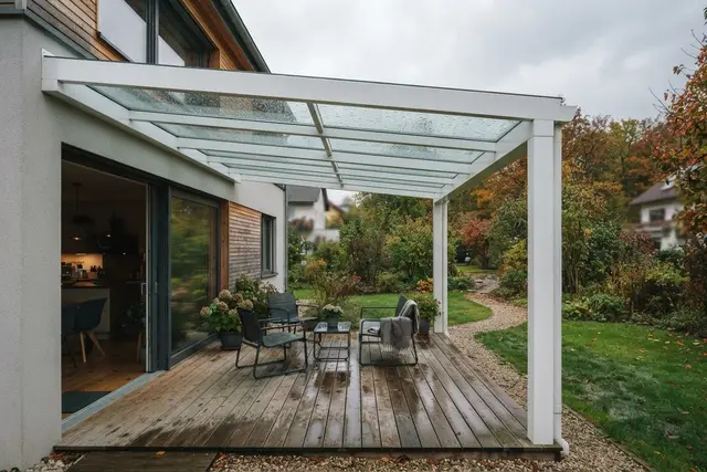 Terrassenüberdachung aus Aluminium und Glas an einem Einfamilienhaus bei Regen