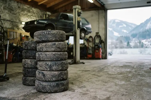 Winterreifenpflicht Österreich: gestapelte Winterreifen in einer kleinen Kfz-Werkstatt im Herbst