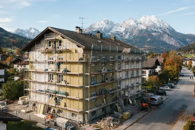 Wohnbauförderung Tirol: Wohnhaus mit Gerüst und Dämmung vor Tiroler Bergen